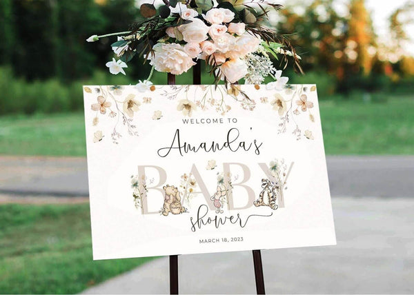 Gender neutral baby shower sign with floral design and personalized text on Canva template, displayed outdoors.